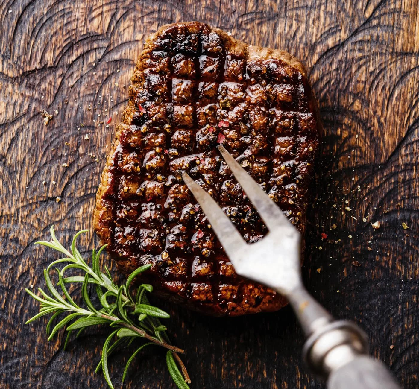 Chargrilled steak with rosemary, cooked to perfection on a cutting board